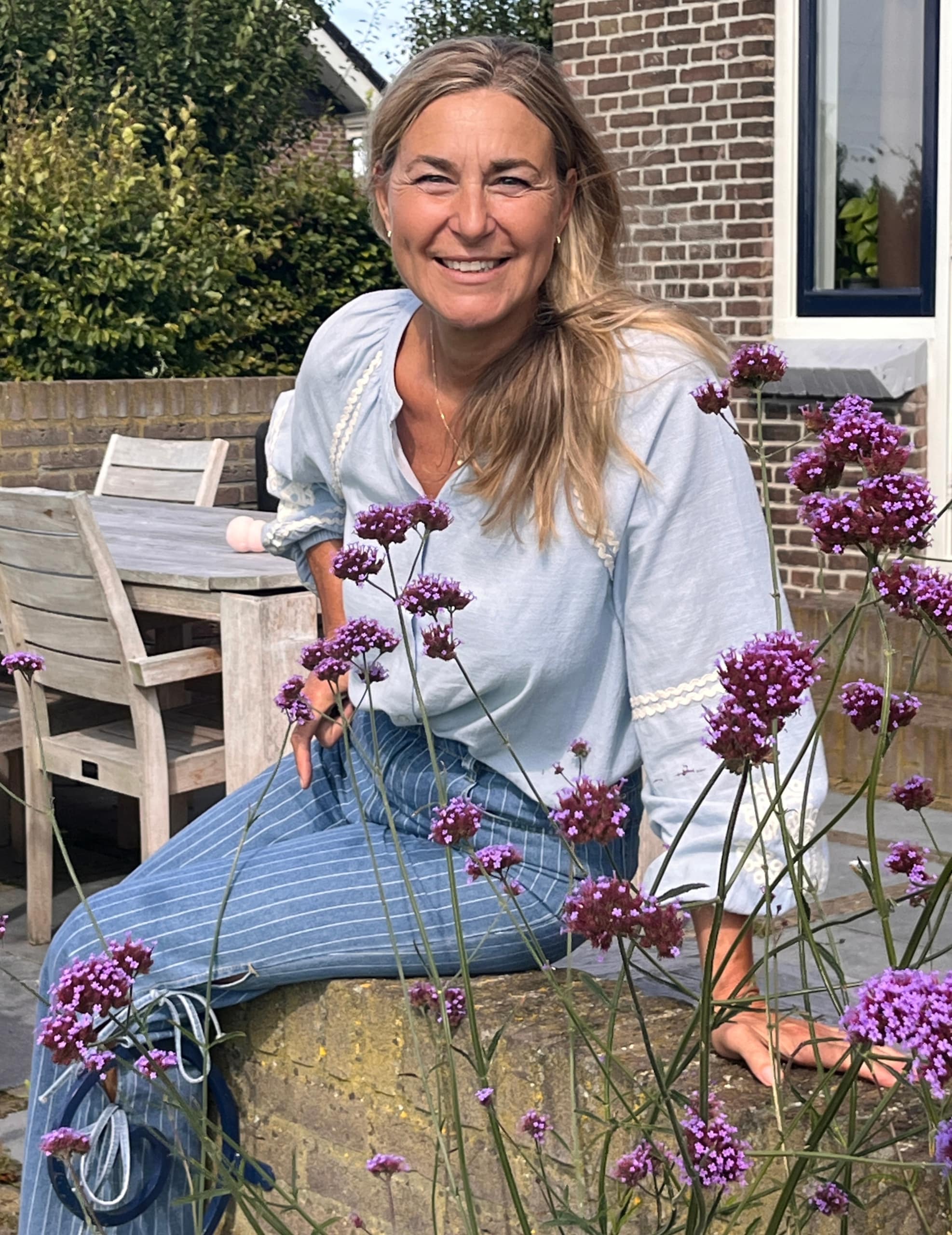 Melanie Bosch tussen bloemen in de tuin